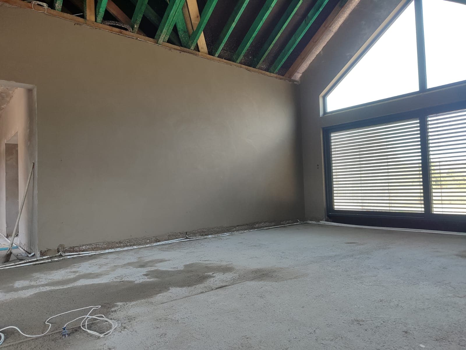 Tynk cementowy na poddaszu z dużym oknem
