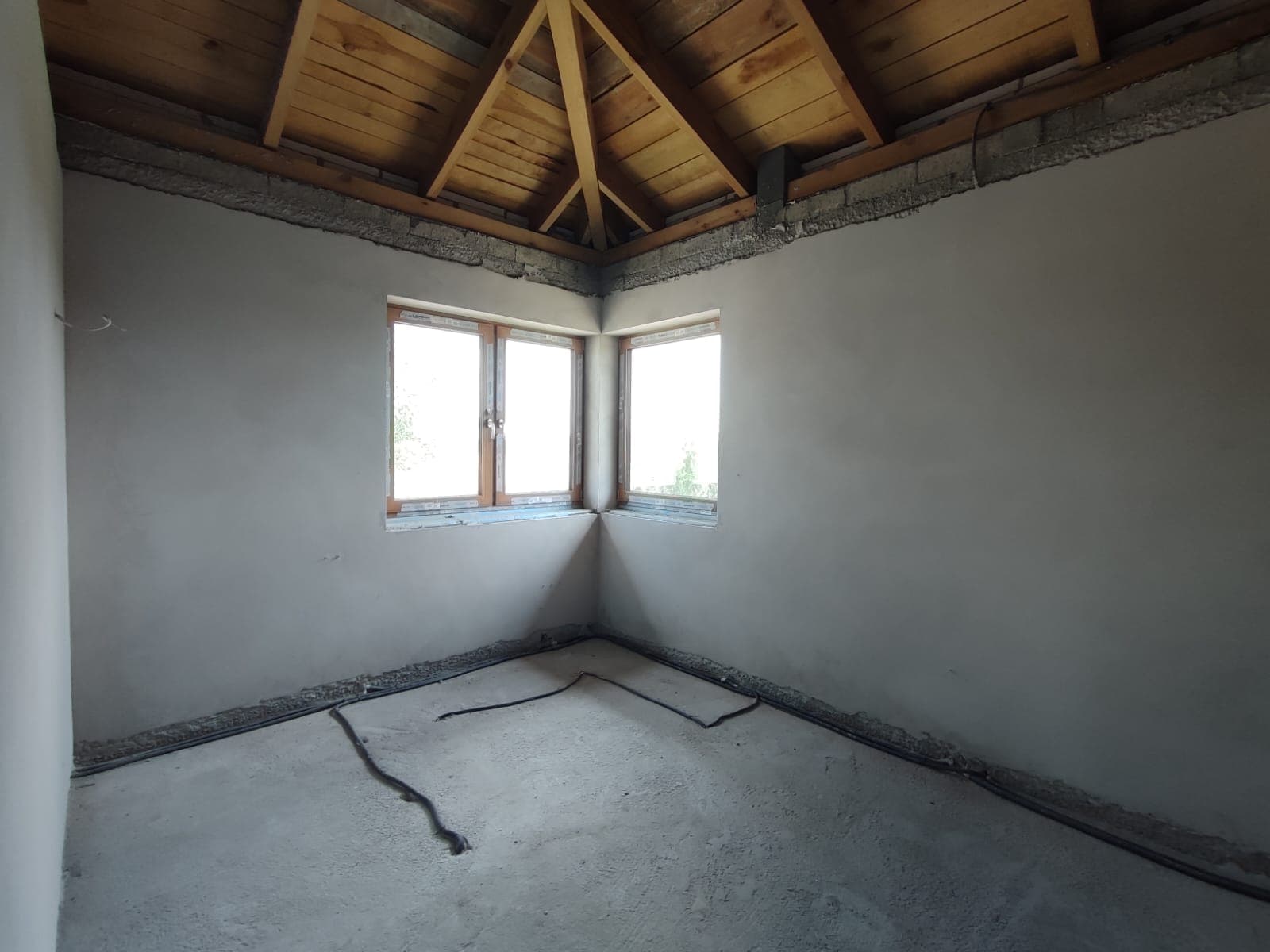 Tynk cementowy na poddaszu z narożnym oknem