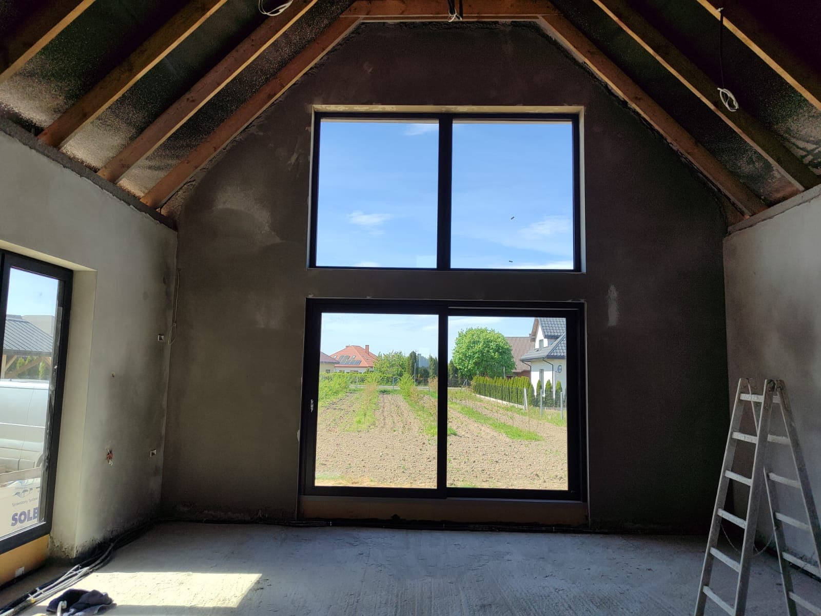 Tynk cementowy na poddaszu z trójkątnym oknem