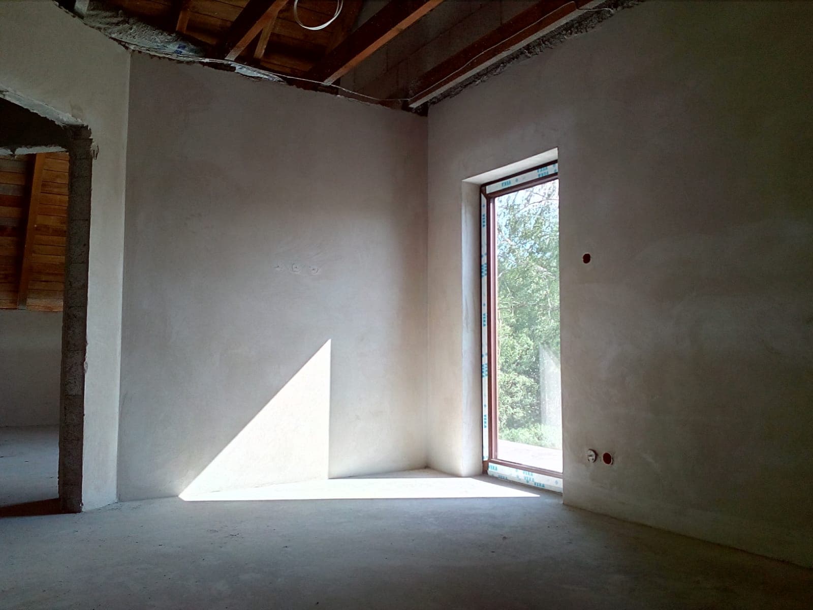 Tynk cementowy w pokoju z drzwiami i oknem