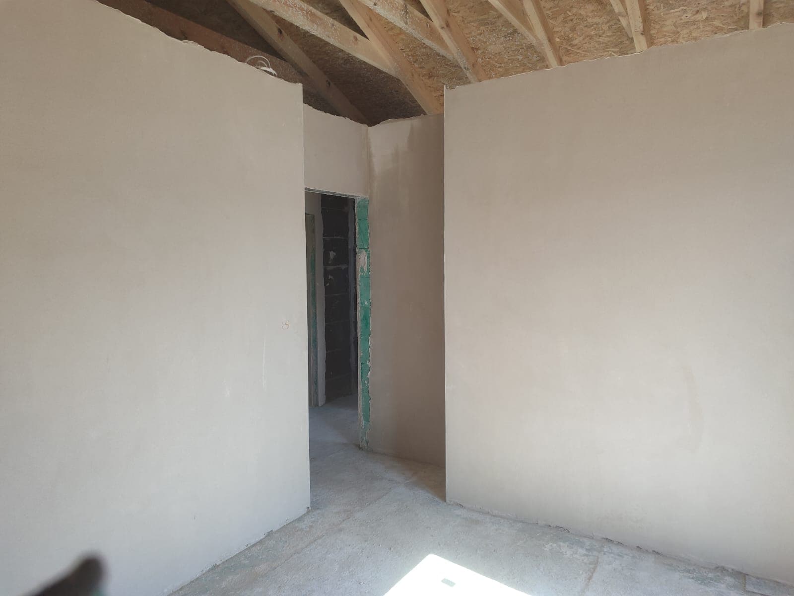 Tynk gipsowy w pokoju z drewnianą więźbą dachową