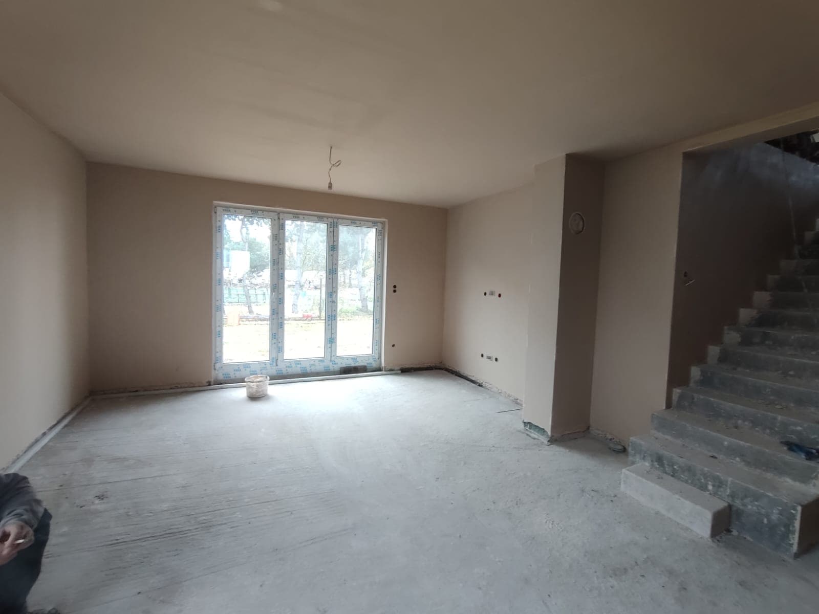 Tynk gipsowy w salonie z balkonem i schodami