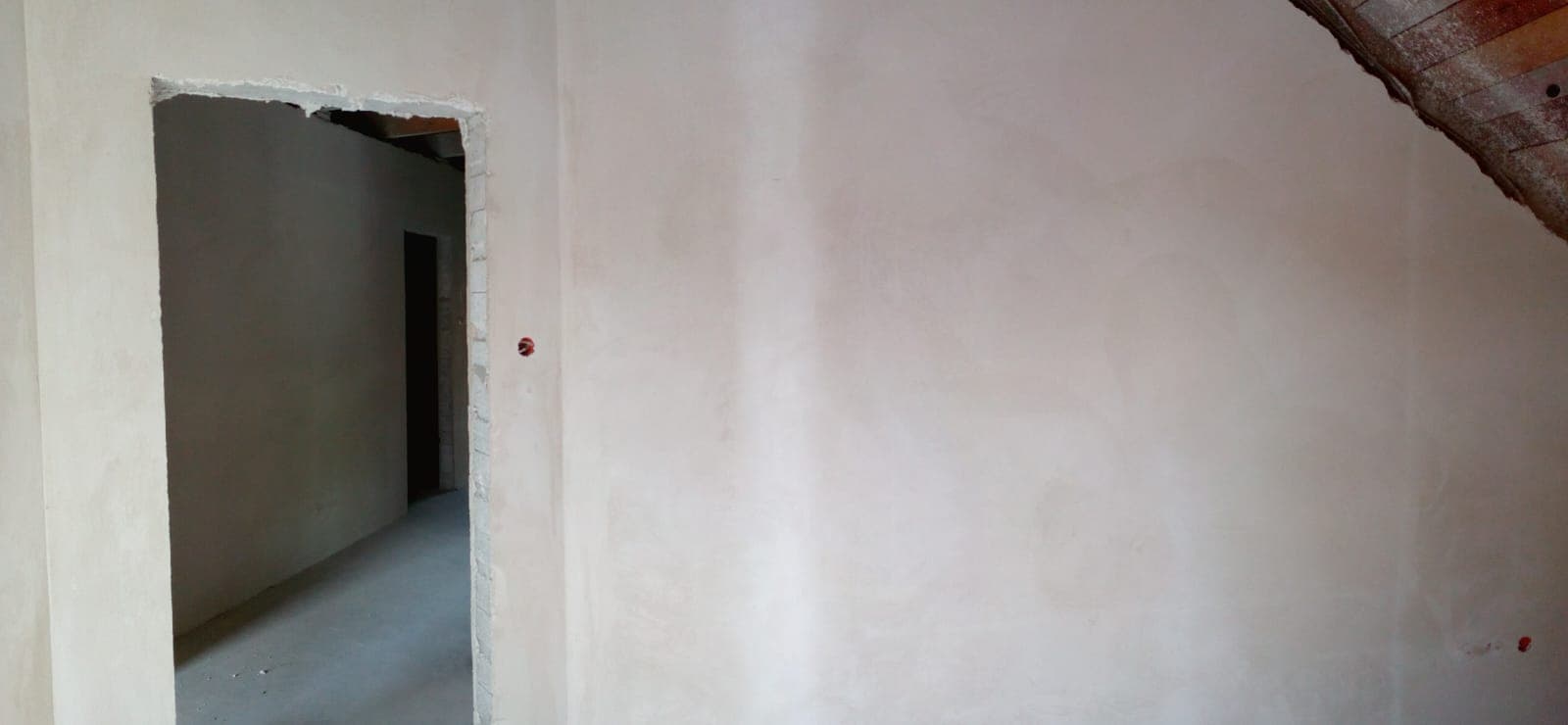 Tynk na ścianie z przejściem do korytarza