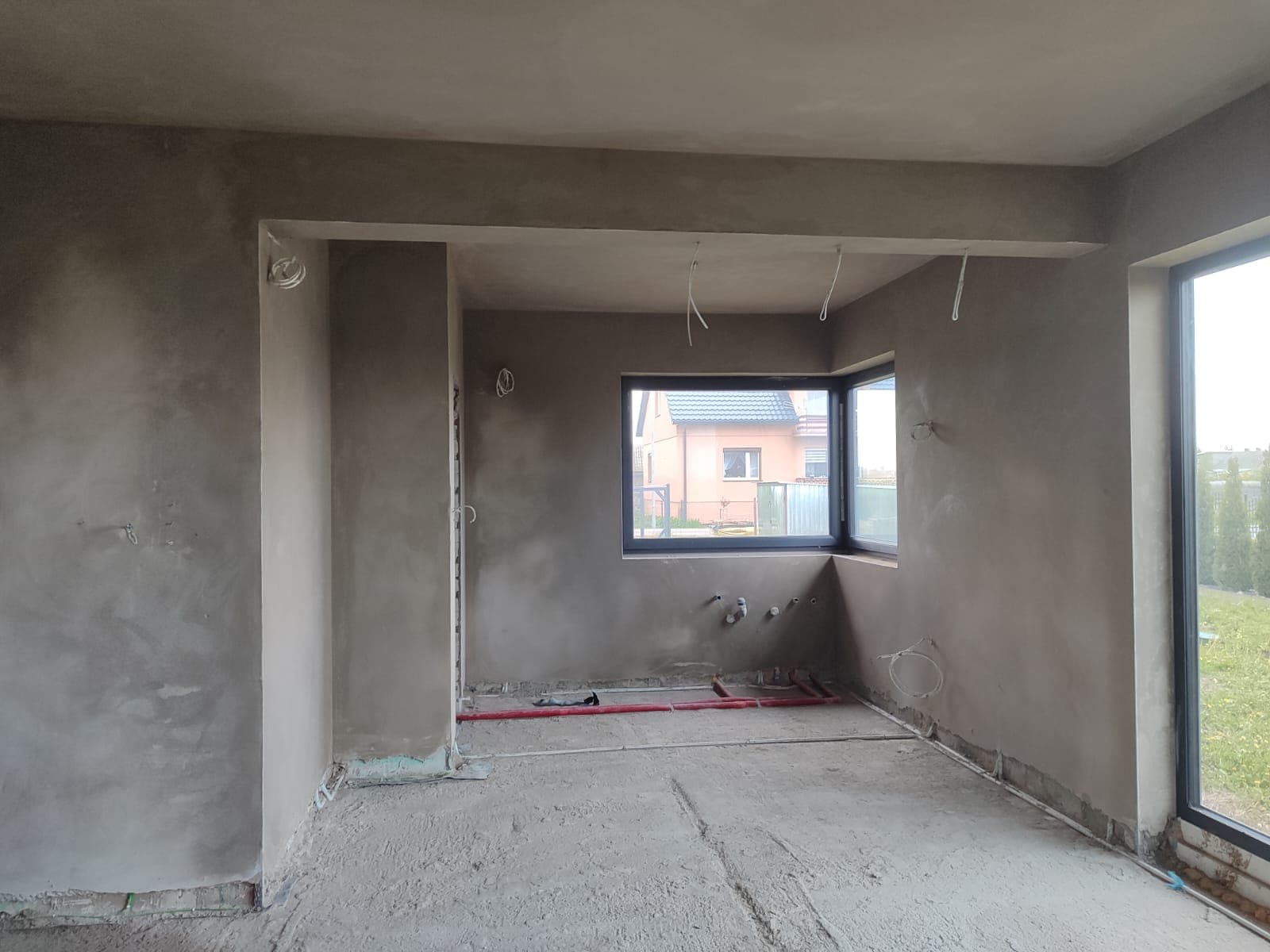 Tynki cementowe w salonie z oknami i instalacjami